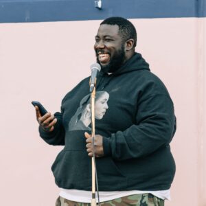 David Gborie standing outside speaking into a microphone